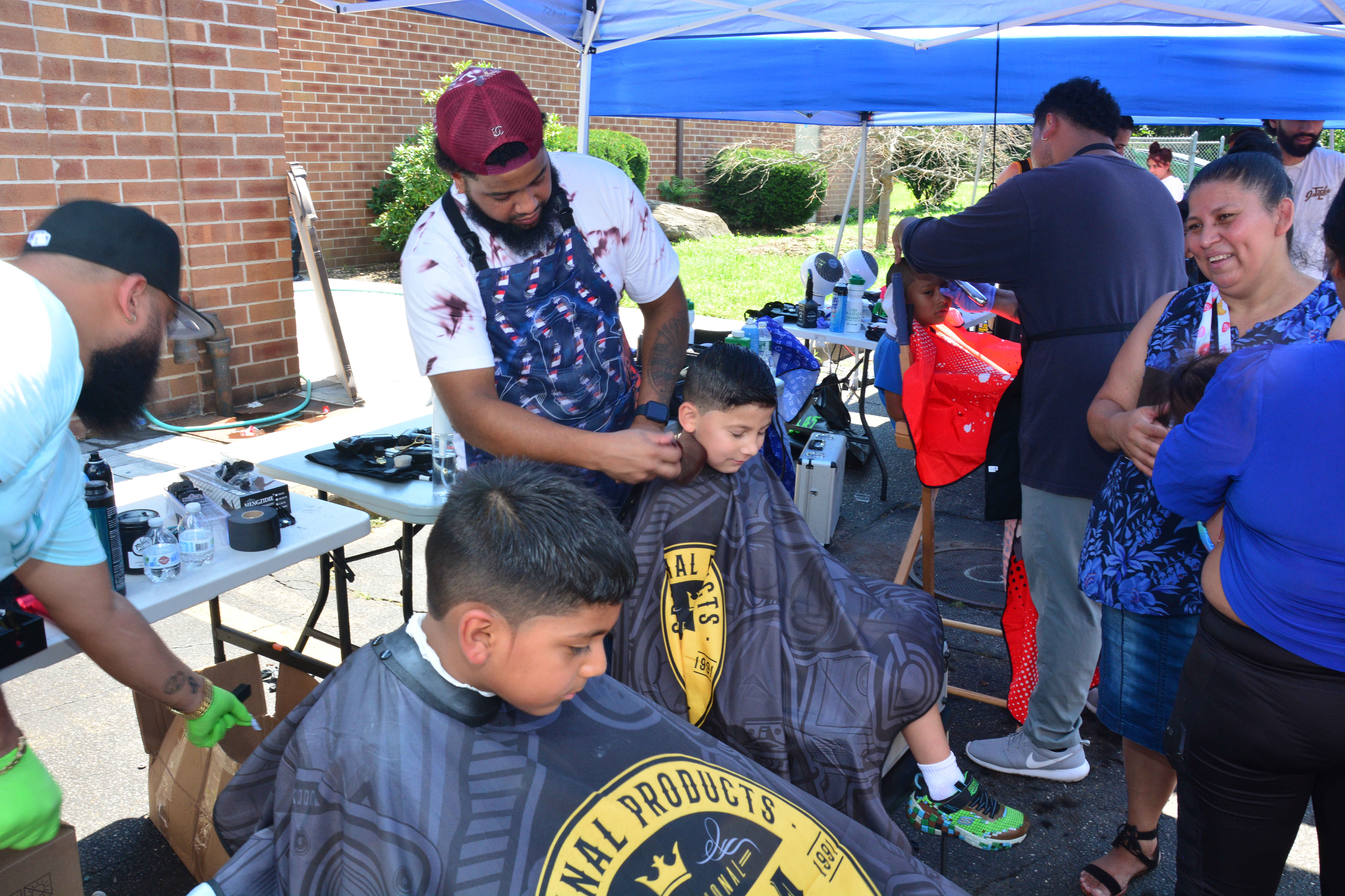 Children who attended New York State Sen. Monica R. Martinez's back-to-school backpack and supply drive distribution event in Brentwood get their hair cut in advance of the upcoming first day of school.