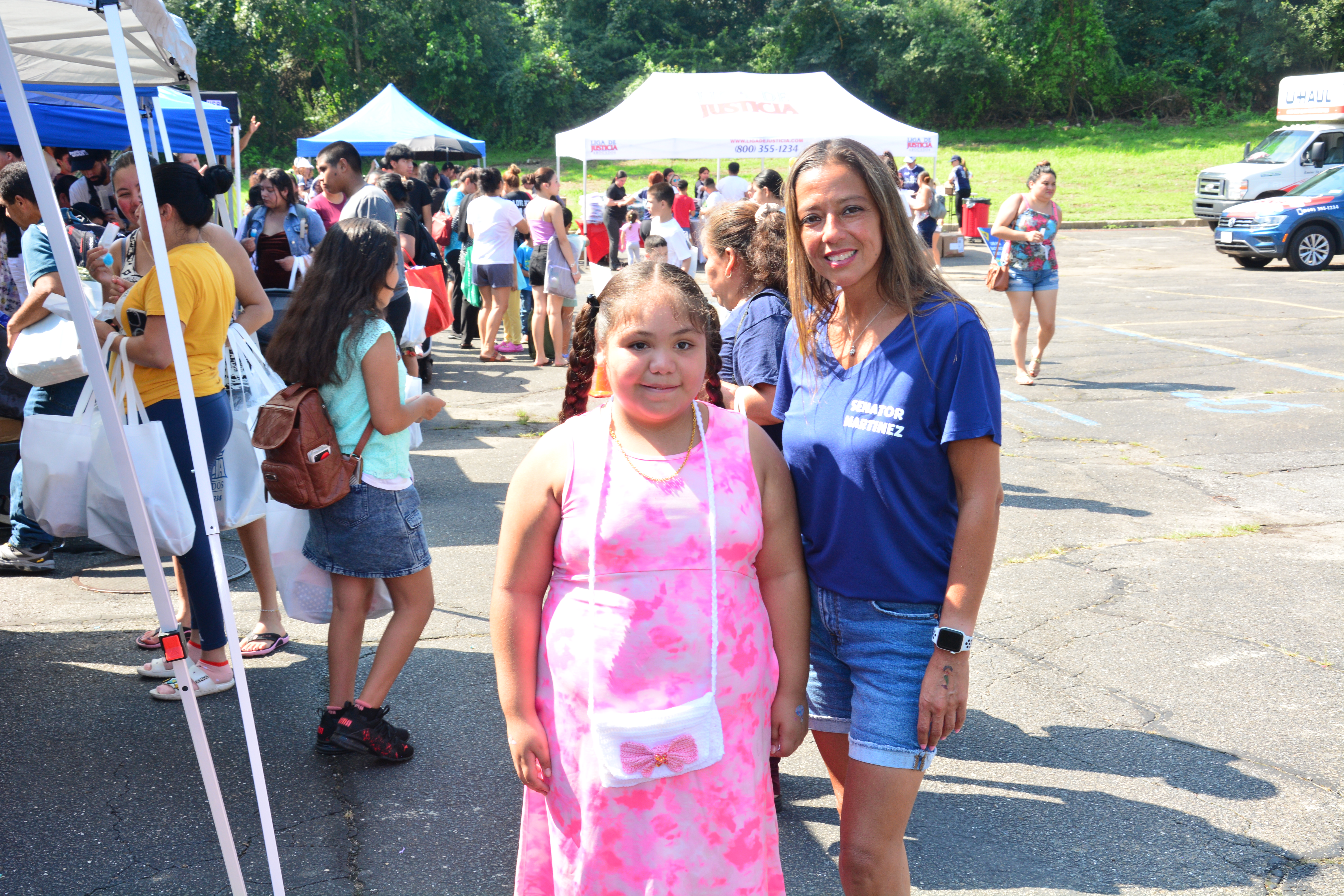 A child who attended New York State Sen. Monica R. Martinez's back-to-school backpack and supply drive distribution event in Brentwood poses for a photo with Senator Martinez.