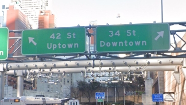 Highway signs for Uptown and Downtown exits from Lincoln Tunnel.