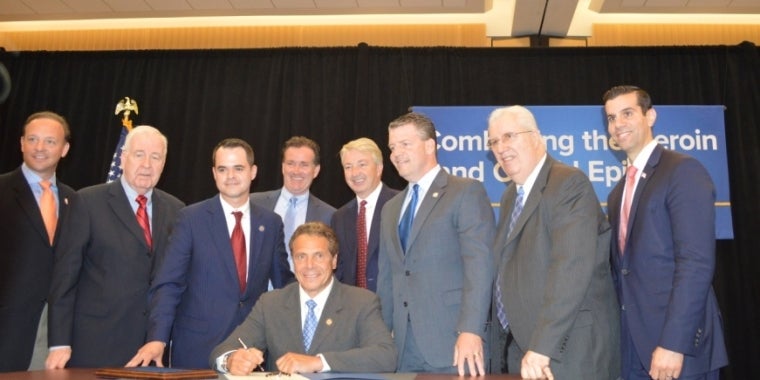 From L to R: Senators Tom Croci, Kemp Hannon, David Carlucci, Majority Leader Flanagan, Governor Andrew Cuomo (seated), Senators Phil Boyle, Terrence Murphy, Carl Marcellino, and Michael Venditto