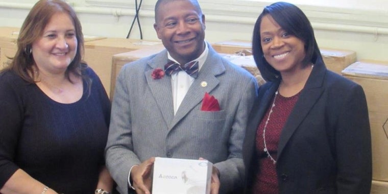 Senator Sanders displays one of the webcams while posting for a photo with School Superintendent Mabel Muniz-Sarduy, left, and Principal Tiffany Hicks.