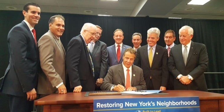 From L to R: Senator Michael Venditto, Assemblyman Joseph Saladino, Senator Carl Marcellino, Peter Elkowitz President/CEO of Long Island Housing Partnership, Governor Andrew Cuomo (seated), Senator Tom Croci, Senator Jack Martins, Suffolk County Executive Steve Bellone, Senator Jeff Klein, and Assemblyman Charles Lavine