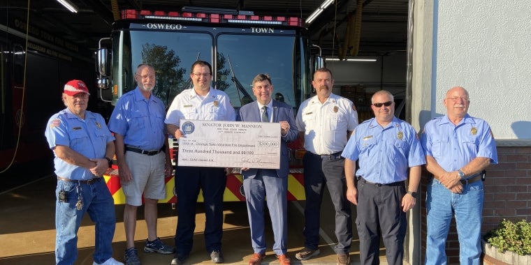 Senator Mannion presents a check to six volunteer firefighters in the Town of Oswego