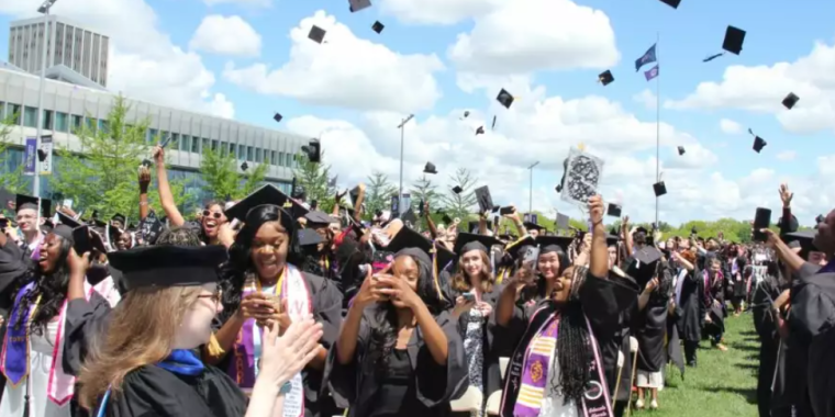 College graduates celebrating on a campus quad.