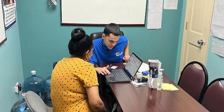 NHSQ intern, Jeremy Colon helps a constituent fill out a Section 8 form.