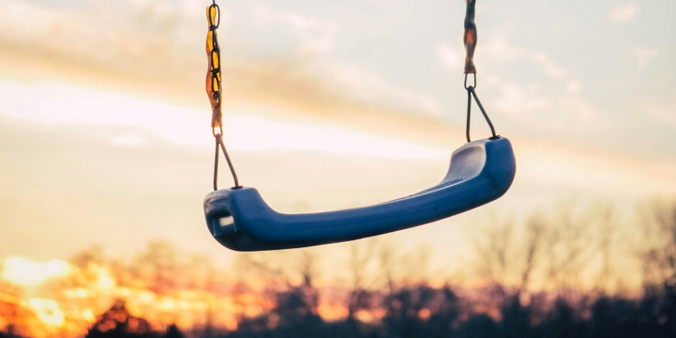 Photo of an empty swing at sunset