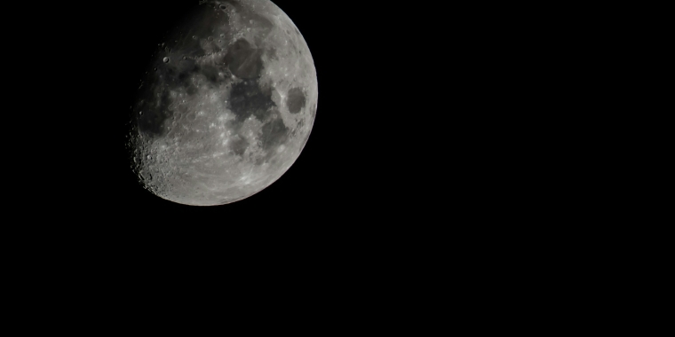 Photo of a partially lit Moon on a clear night