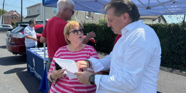 Senator Addabbo speaks with a constituent about his list of upcoming events.