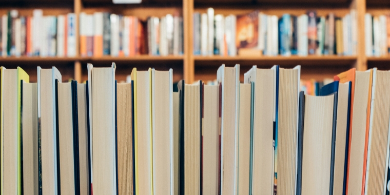 Photo - Books stacked on library shelves.