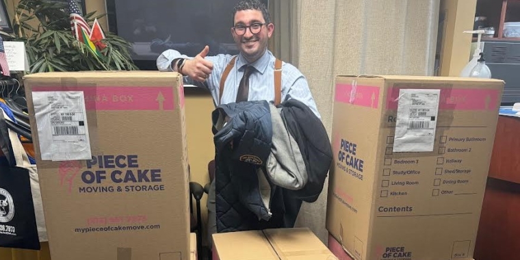 Senator Addabbo's Chief of Staff, Raimondo Graziano, displays the boxes of coats that will be shipped to NYC Cares.