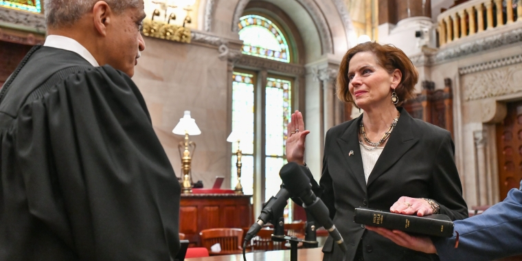 Senator Patricia Fahy's swearing-in: Senator Fahy placing her hand on a bible and taking the oath of office in the NYS Senate Chamber.