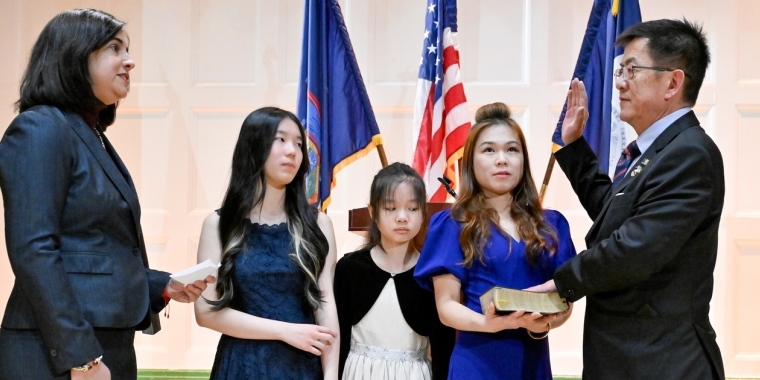 Senator Stephen T. Chan of Senate District 17, joined by his two daughters and his wife, is sworn in by Congresswoman Nicole Malliotakis. 