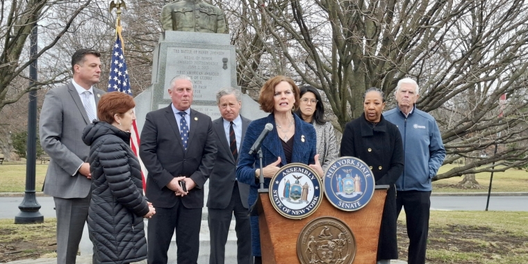 Senator Fahy and local elected officials stand in front of the Henry Johnson statue in Washington Park, Albany.