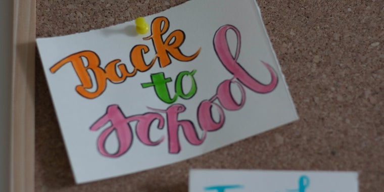Photo image of a note reading "Back to School" tacked onto a corkboard.