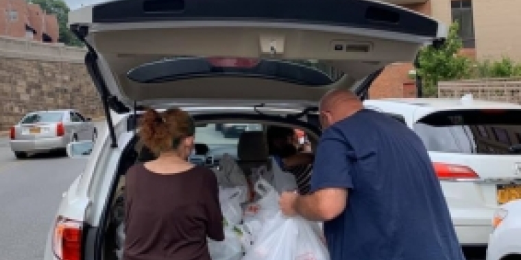 Volunteers unload a car with supplies 