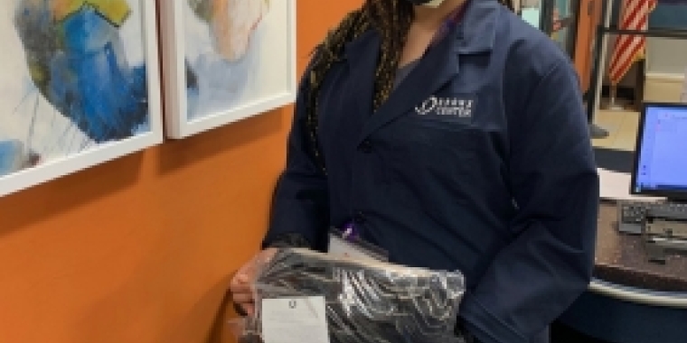 A healthcare worker at Bronx Center for Rehabilitation and Health Care holds the masks delivered by Team Biaggi