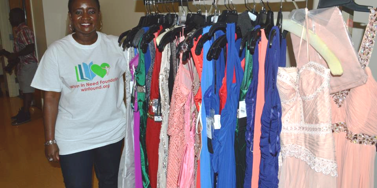 Chetachi Nwoga-Ecton, Executive Director of the When in Need Foundation, shows off some of the prom dresses that were to be given away.
