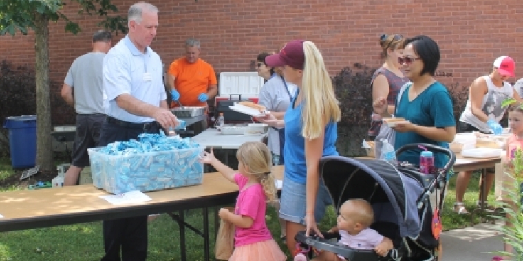 Senator Ranzenhofer hands out rice krispies treats during a picnic at the Amherst Library.