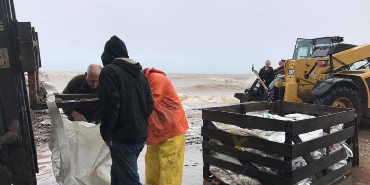 Workers and volunteers put sandbags near the docks at Bald Eagle Marina in Kendall as Lake Ontario creeps closer.