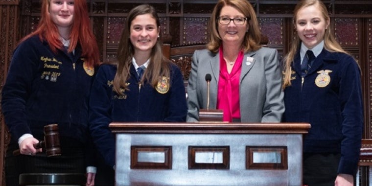 Senator Pam Helming stands in the New York State Senate Chamber with Tully Junior-Senior High  School Future Farmers of America members Meghan Weaver, left, and Sydney Grosso, center,  and Southern Cayuga Junior-Senior High School FFA member Catherine Kopp.