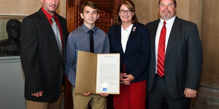 From left, Palmyra-Macedon Red Raiders wrestling coach John Burgess, NYSPHSAA Division II 99-pound state champion Jace Schafer, Senator Pam Helming, and Palmyra-Macedon Central School District Athletic Director Tom Schmandt.