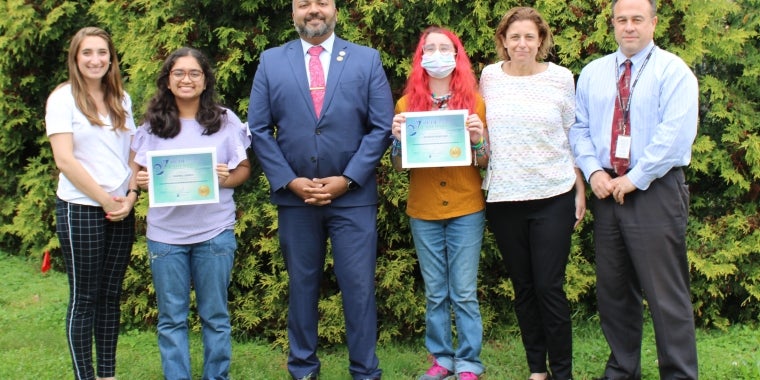 Senator Kevin Thomas presents Mahira Ahmed and Addison Baroukh of East Meadow High School with the NYS Youth Leadership Recognition Award, accompanied by principal Richard Howard, left, and guidance counselors Joanna Silberman and Carly Salzman
