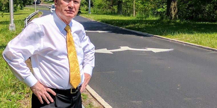 Senator Avella stands at location of DOT’s dubious signage
