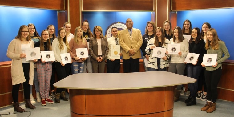 Senator Pam Helming, Wayne Central School District Athletic Director Anthony Carusone, and Superintendent Mathis Calvin III stand with members of the Wayne Eagles girls varsity volleyball team that won the Section V championship.