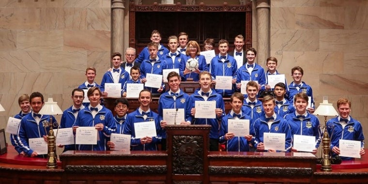 Senator Pam Helming stands with members of the Lansing High School Bobcats boys soccer team that won the 2018 New York State Public High School Athletic Association Championship, the team’s second straight Class C state title. Joining in the celebration in the State Senate chamber were Head Coach Benji Parkes, his coaching staff, and the 28 players.