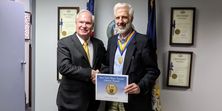 Senator Avella (l.) presents Walter Mugdan with Liberty Medal
