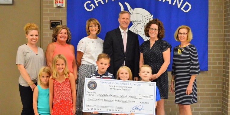 Senator jacobs is pictured presenting a ceremonial check to Sidway Elementary school students, parents and administrators for the purchase and installation of a brand new ADA compliant playground.