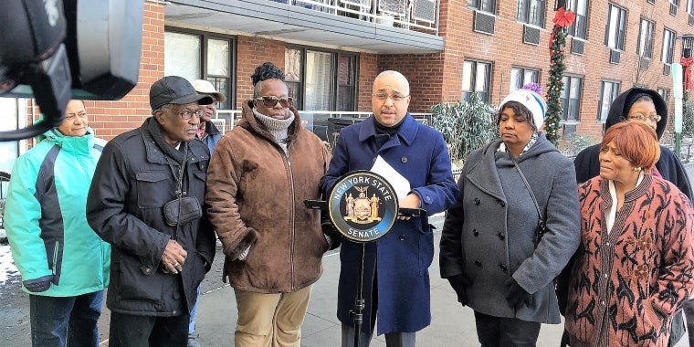 State Senator Jose Peralta, flanked by tenants during his announcement.
