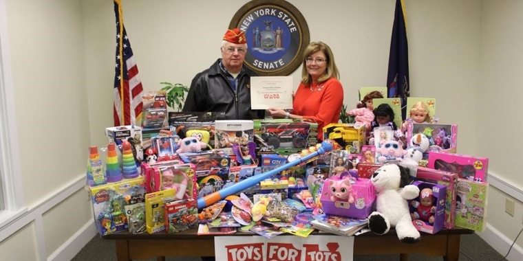 Marine Corps League Memorial Day Detachment No. 468 Senior Vice Commandant David Brisbane presents a certificate to Senator Pam Helming to thank her for her participation in the annual Toys for Tots program last year.