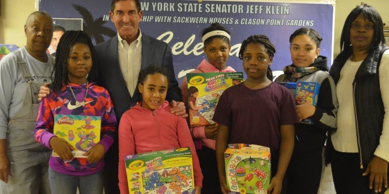 Photo caption: (left to right): Sackwern Residents Association President Loretta Masterson, Senator Jeff Klein, and Clason Point Tenants Association President Geraldine Hopper are joined by local children as they celebrate Three Kings Day.