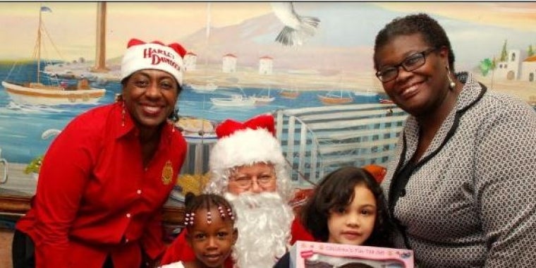 President of the Newton Foundation Judy Newton(left), Santa with children in attendance and State Senator Roxanne Persaud.