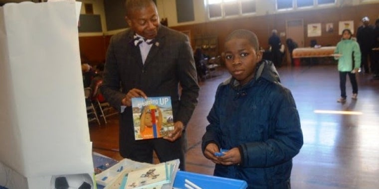 Senator Sanders encourages a young student who was experimenting with building blocks to "Dream Up, as the title of the book says.