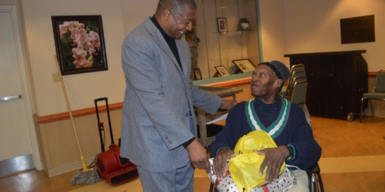 Senator Sanders gives a blanket and backpack with gifts to veteran, Arthur Adams.