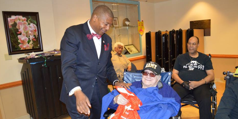 Senator Sanders presents a sweatshirt and gift bag to Seymour Hoffnug, an Army veteran, who served in World War II and Vietnam.